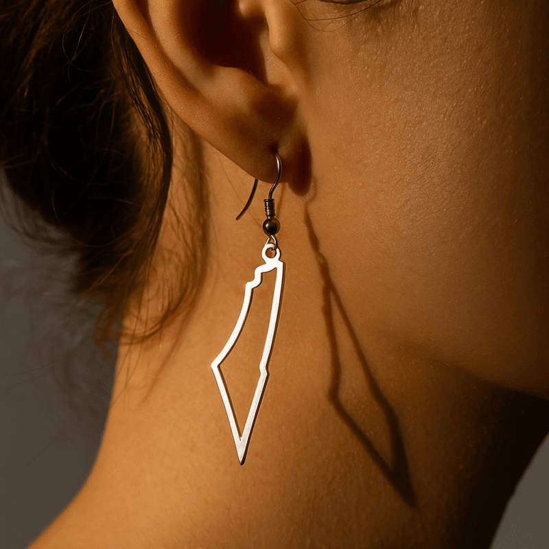 Boucle d’oreille argentée en forme de Palestine, portée à l’oreille, style minimaliste et engagé