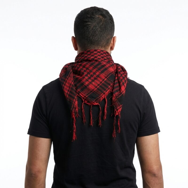 Foulard Keffieh en coton rouge et noir, drapé avec des franges, porté par un homme de dos.